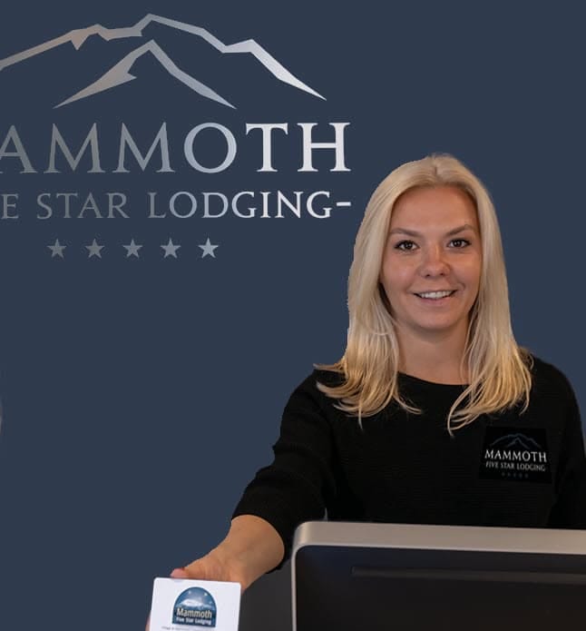 Two women standing in front of a sign that says hammoth star lodge.