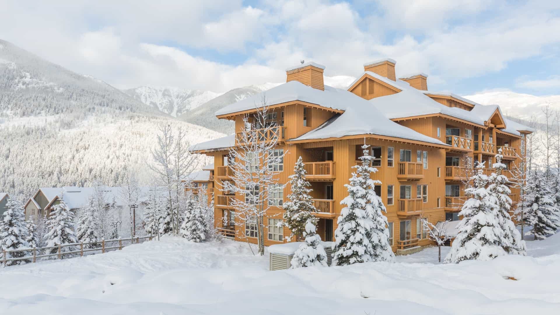 A large building is surrounded by snow and trees.