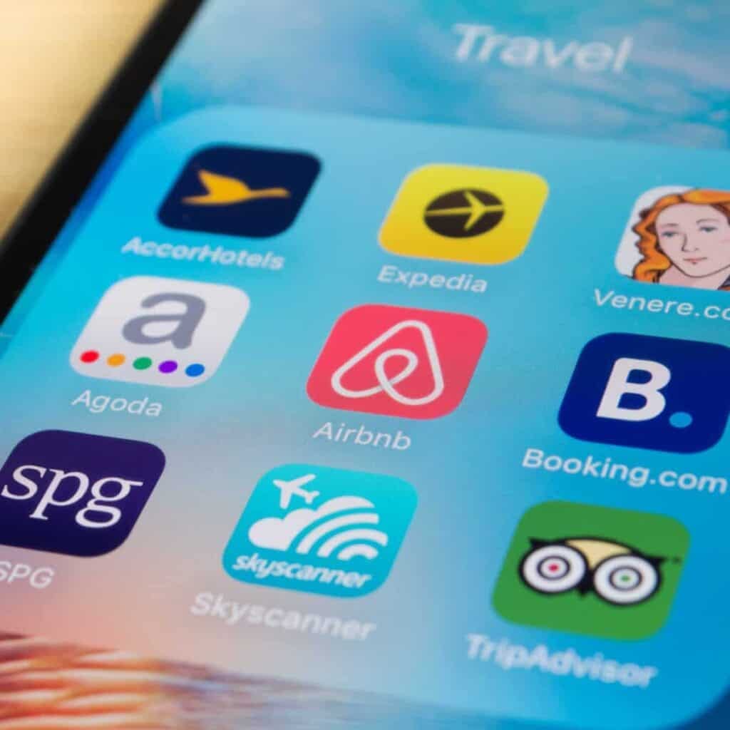 A smartphone with travel apps and property management displayed on it.