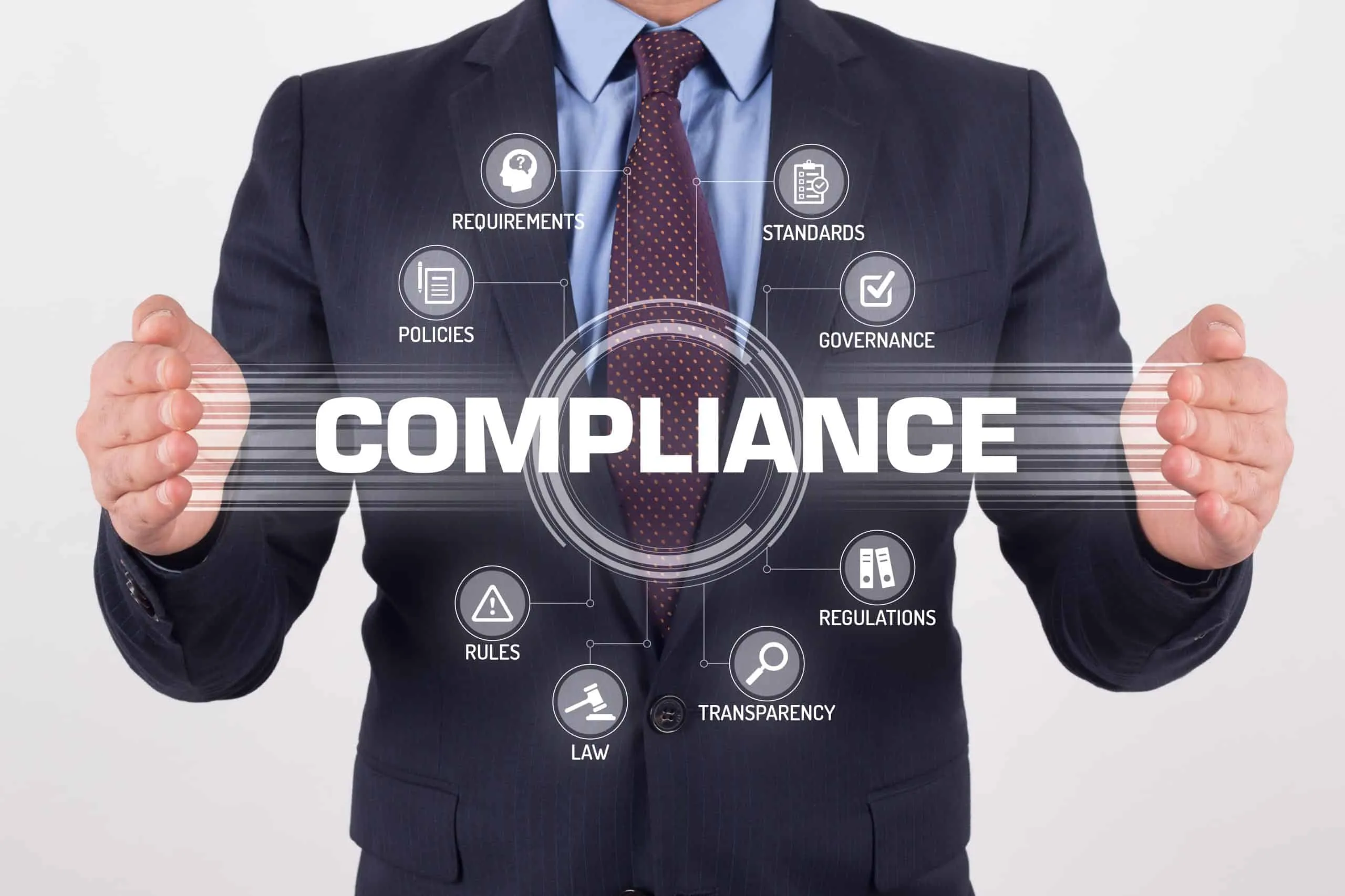 Let's talk A man in a suit holding up the word compliance.