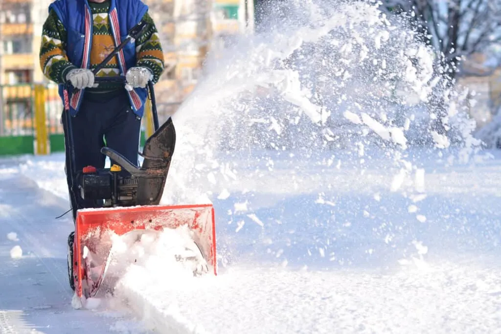 A ___________ using a snow blower in the ________.