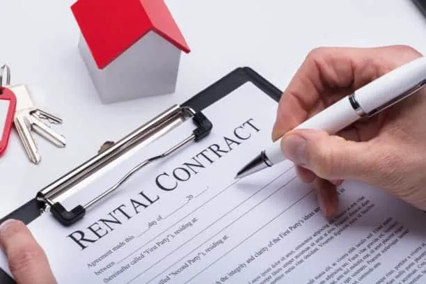 A person signing a rental contract on a clipboard.